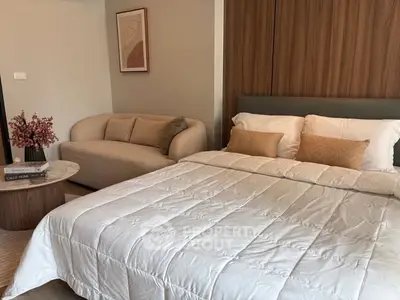 Elegant bedroom with cozy sofa and modern decor, perfect for relaxation and comfort.