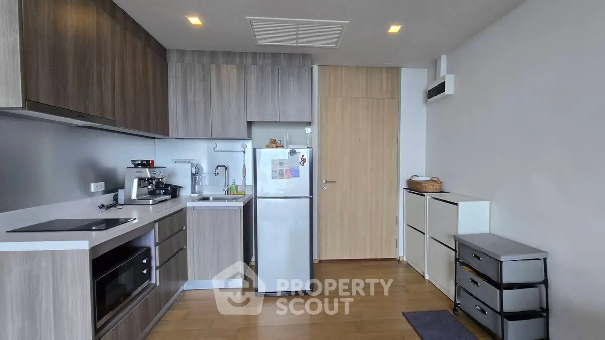 Modern kitchen with sleek cabinetry and compact appliances in a stylish apartment.