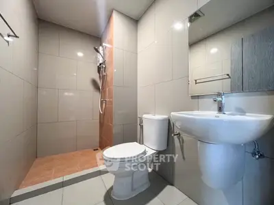 Modern bathroom with sleek fixtures and walk-in shower in contemporary apartment.