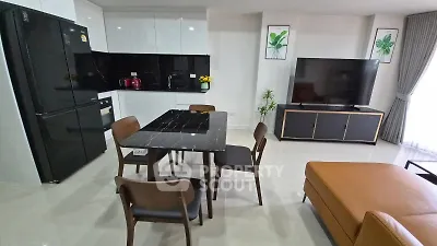 Modern open-plan living room with sleek kitchen and stylish furniture