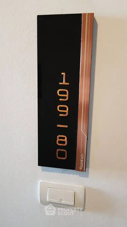 Modern apartment number sign with sleek design on white wall, perfect for contemporary living spaces.