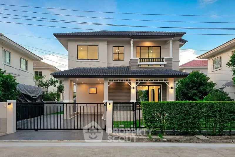 Stunning modern two-story house with lush garden and secure gated entrance in a serene neighborhood.
