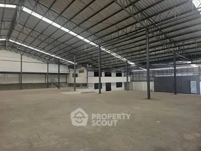 Spacious industrial warehouse with high ceilings and steel framework, ideal for storage or manufacturing.