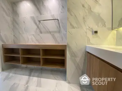 Sleek modern bathroom with marble tiles and elegant wooden vanity, featuring ample storage and sophisticated design.