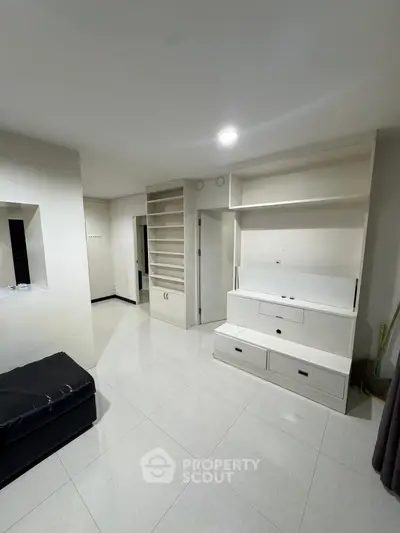 Spacious living room with built-in storage and modern white tiles