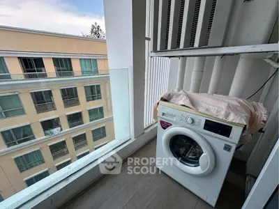 Modern apartment balcony with washing machine and city view, ideal for urban living.