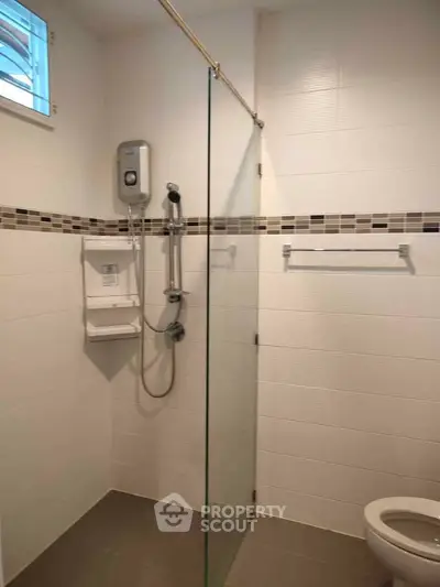 Modern bathroom with glass shower partition and wall-mounted water heater