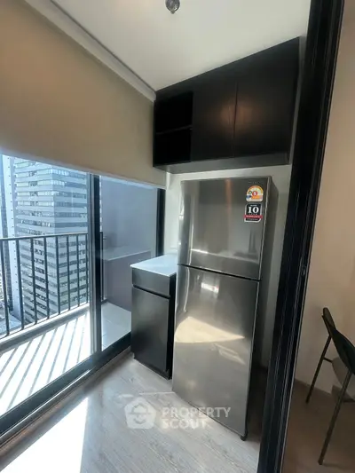 Modern kitchen with stainless steel fridge and balcony view in urban apartment