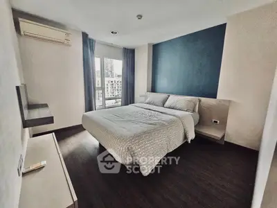 Modern bedroom with city view, featuring sleek design and ample natural light.