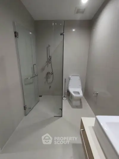 Modern bathroom with glass shower and sleek fixtures in a contemporary home.