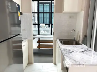 Modern kitchen with marble countertops and large window