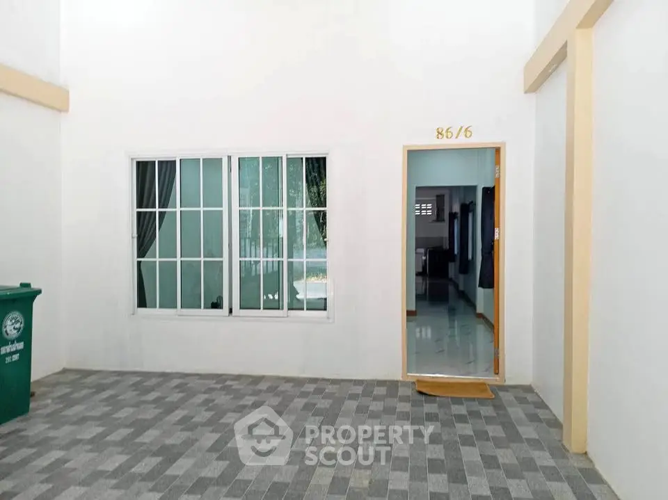 Charming entrance with large window and tiled flooring, perfect for welcoming guests.