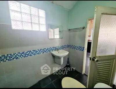 Charming bathroom with modern sink and tiled walls, featuring a frosted glass window for natural light.