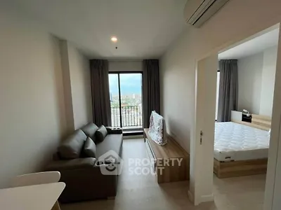 Modern apartment interior with living room and bedroom, featuring sleek furniture and a city view.