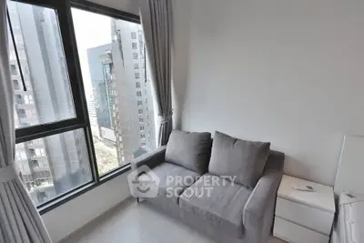Modern apartment living room with city view and cozy gray sofa.