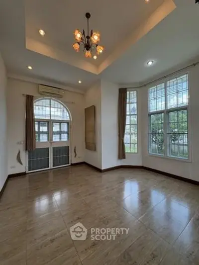 Spacious living room with elegant chandelier and large windows