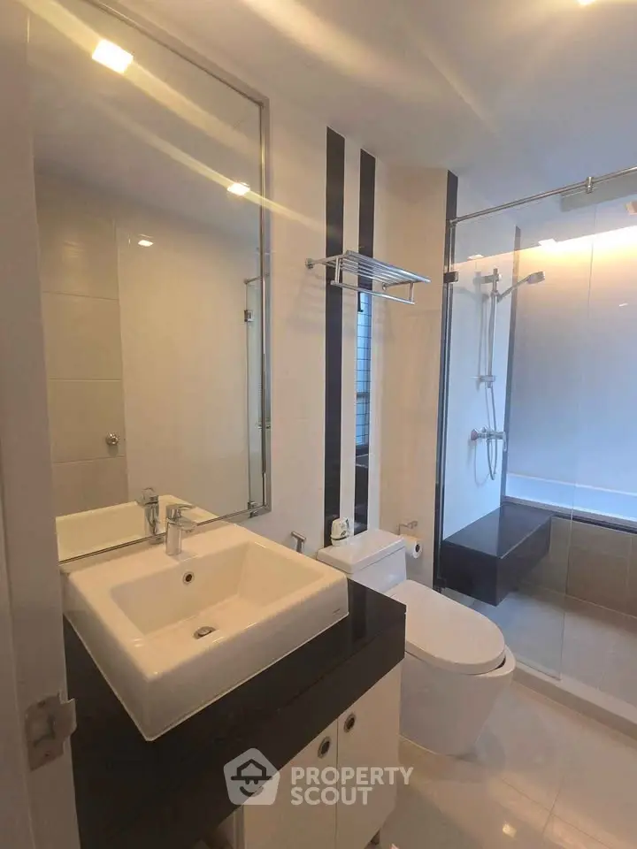 Modern bathroom with sleek fixtures and glass shower enclosure