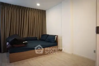 Cozy bedroom with wooden flooring and elegant curtains, perfect for restful nights.