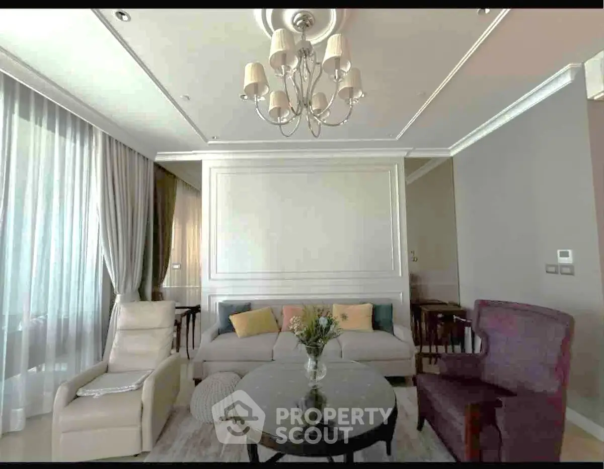 Elegant living room with stylish chandelier and cozy seating area, perfect for relaxation and entertaining.