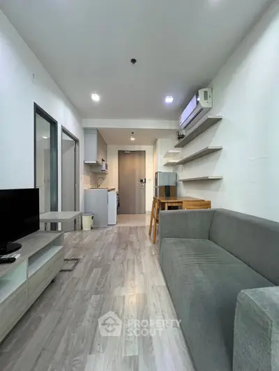 Modern living room with sleek furniture and open kitchen layout in a stylish apartment.