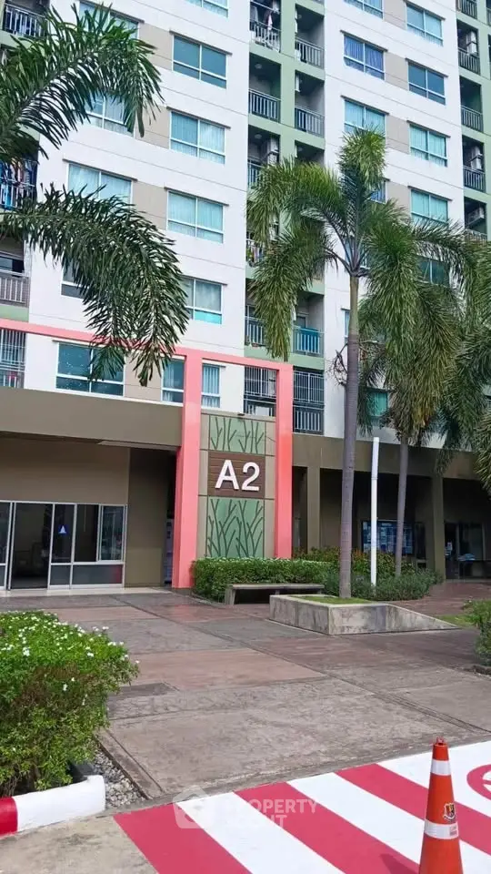 Modern condominium building exterior with palm trees and entrance marked A2.