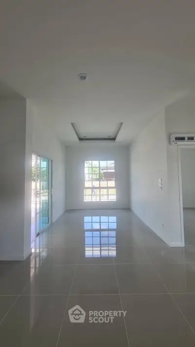 Spacious empty room with glossy tiled floor and large window view