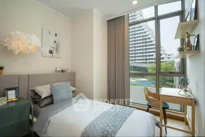 Modern bedroom with large window and stylish decor overlooking a scenic view.