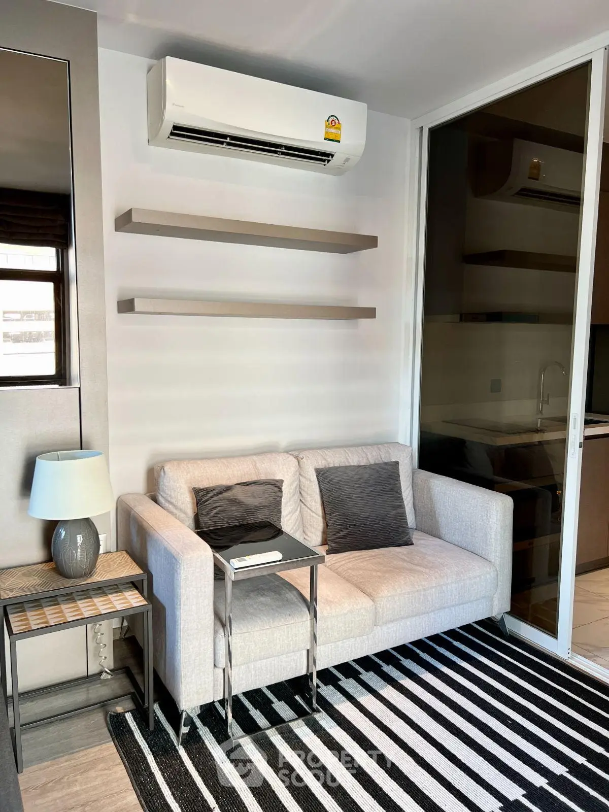 Modern living room with sleek air conditioning, cozy sofa, and stylish decor in a contemporary apartment.