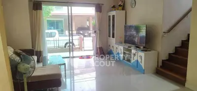 Spacious living room with modern decor and large sliding glass doors leading to balcony.