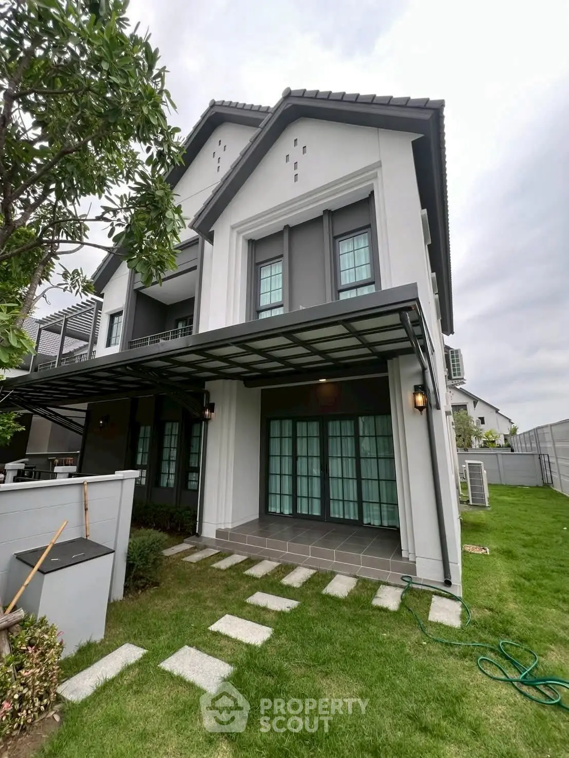 Modern two-story house with spacious lawn and stylish exterior design.