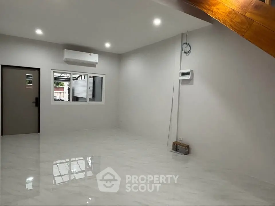 Spacious unfurnished room with modern air conditioning and glossy tile flooring