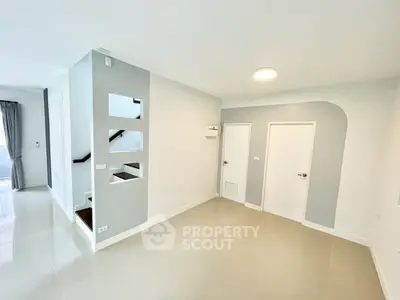 Spacious modern living area with sleek design and neutral tones