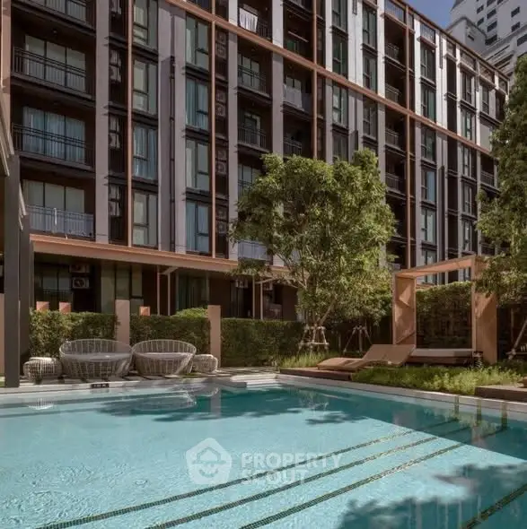 Luxurious modern apartment building with inviting pool and lush greenery