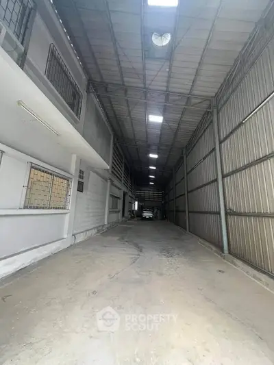 Spacious industrial warehouse with high ceilings and secure gated entry.