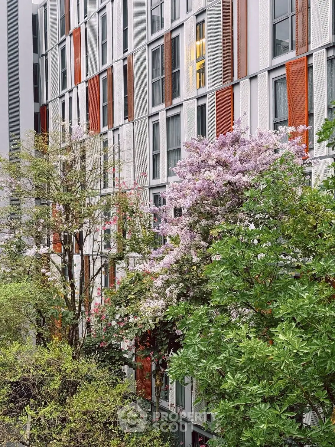 Modern apartment building exterior with colorful panels and lush greenery