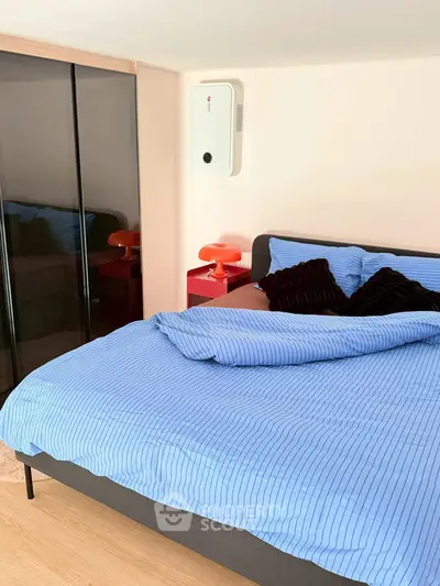 Cozy bedroom with modern decor and stylish bedding in a real estate property.