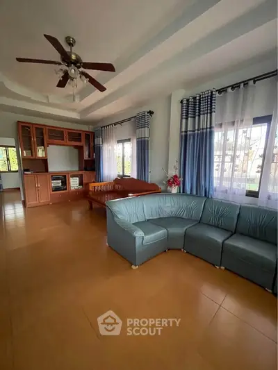 Spacious living room with modern ceiling fan and cozy sectional sofa