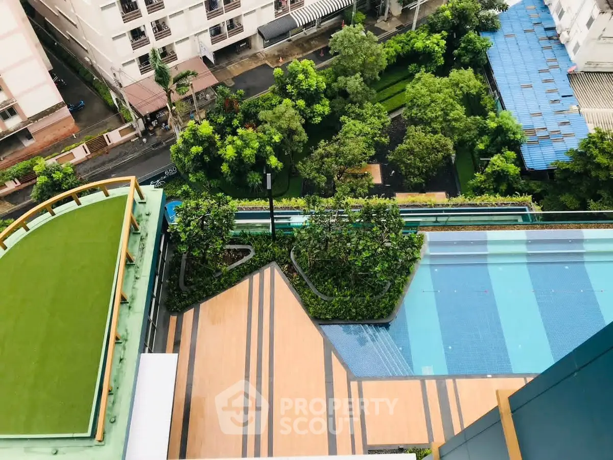 Stunning aerial view of modern rooftop pool and lush garden in urban setting.