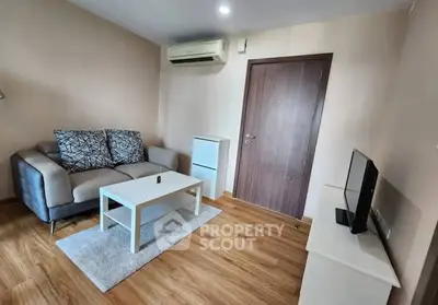 Cozy living room with modern sofa, TV, and air conditioning