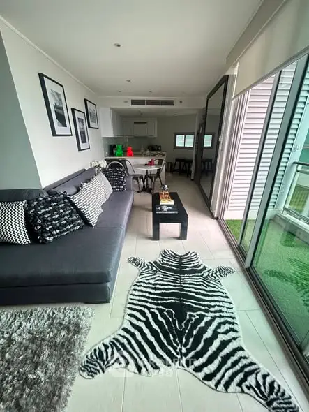 Stylish modern living room with zebra rug and open kitchen layout in a bright apartment.