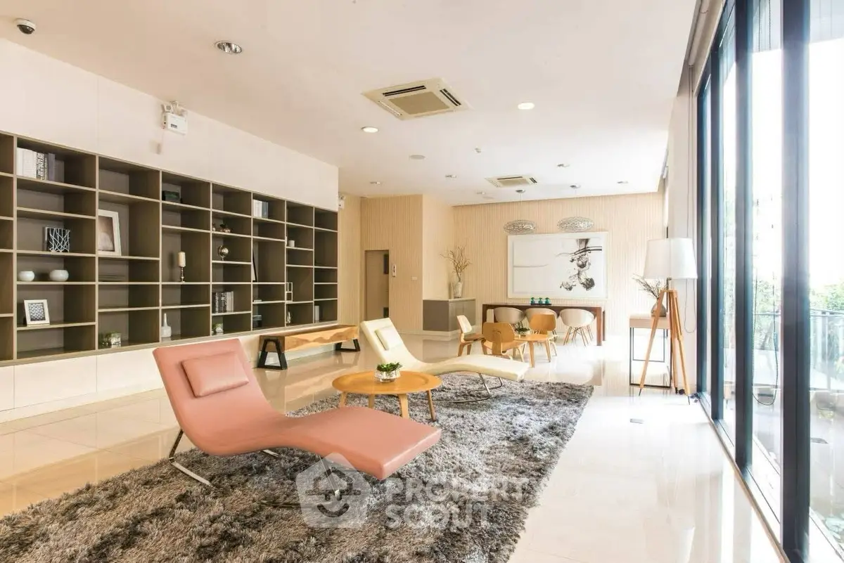 Spacious modern living room with stylish furniture and large windows offering natural light.