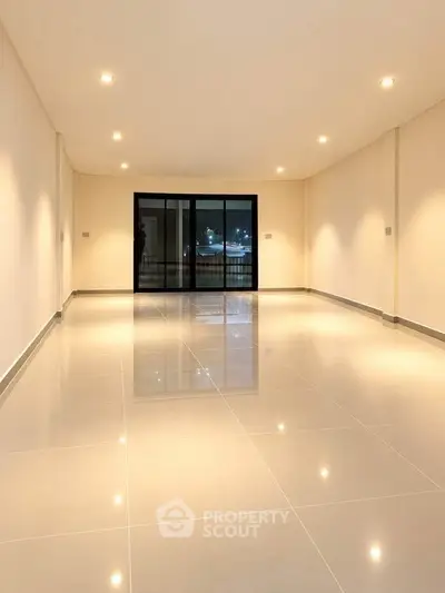 Spacious modern living room with glossy tiled floors and large windows.