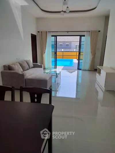 Spacious living room with pool view and modern furnishings