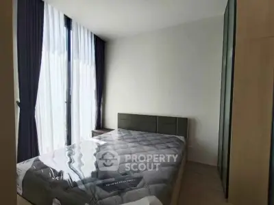 Modern bedroom with large windows and stylish curtains, featuring a comfortable bed and sleek wardrobe.