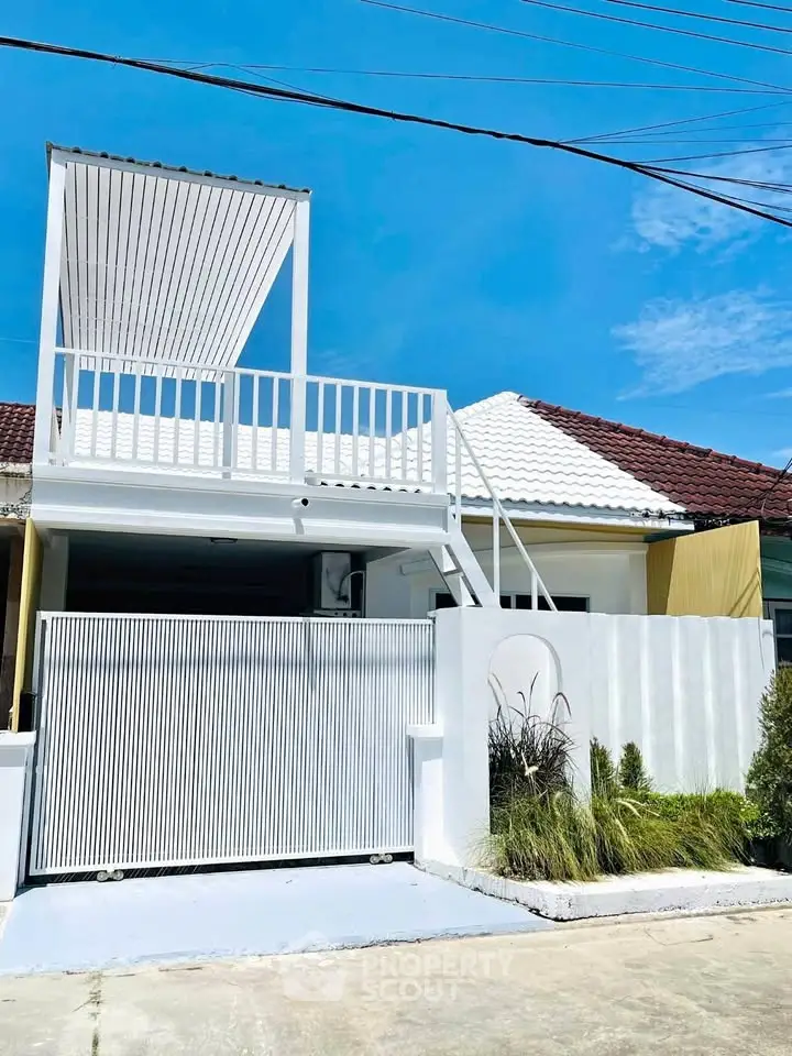 Charming modern house with white facade and rooftop terrace in sunny neighborhood.