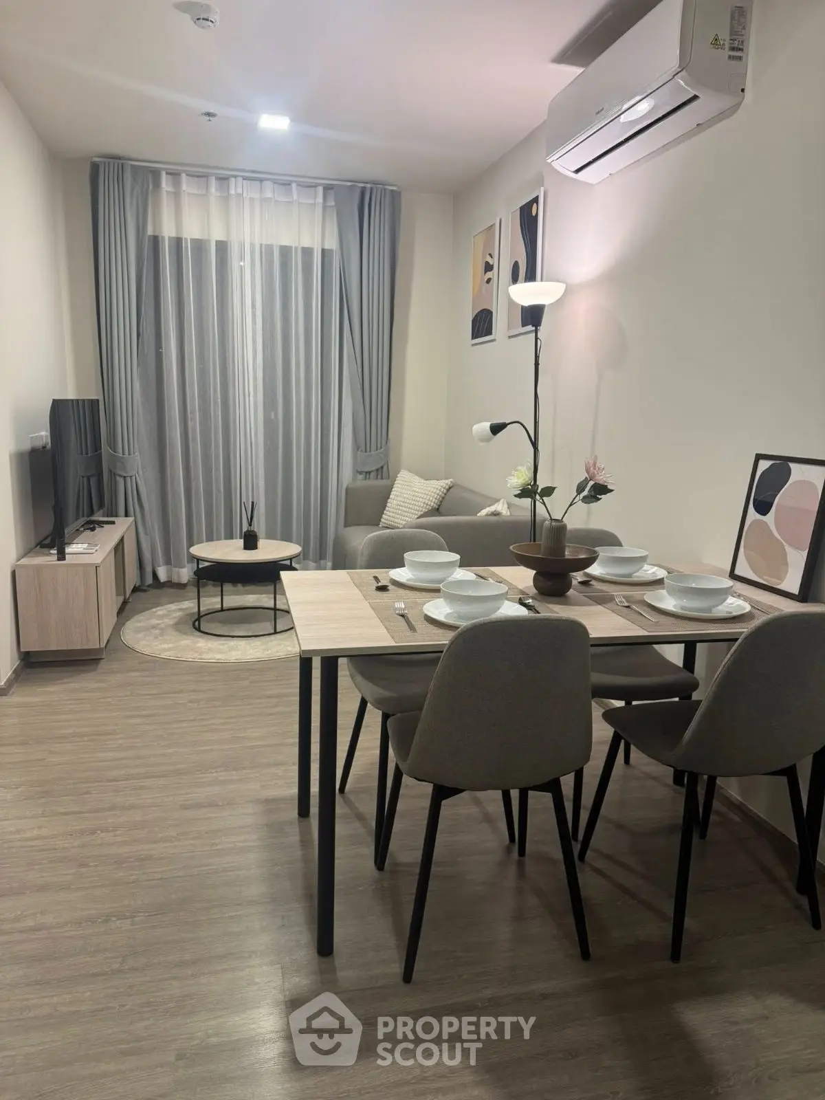 Modern living room with dining area, stylish decor, and natural light.