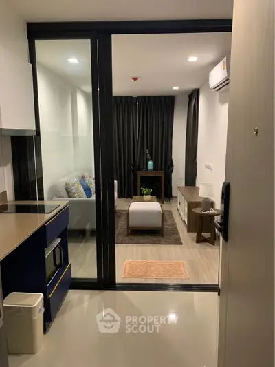 Modern open-layout living room with sleek kitchen and cozy seating area, perfect for urban living.