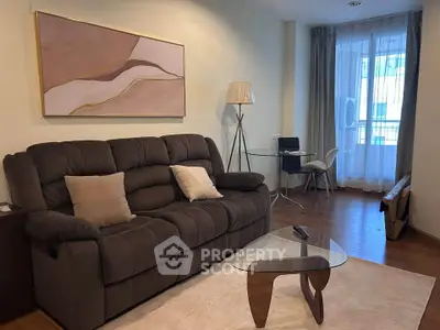 Cozy living room with plush sofa, modern art, and natural light from large window.