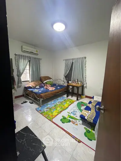 Cozy bedroom with double bed, playful decor, and natural light.