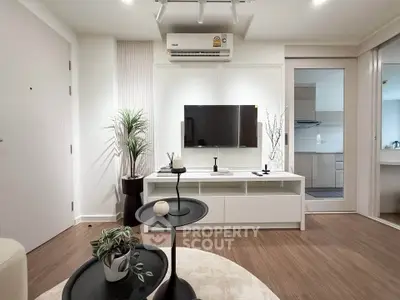 Modern living room with sleek design, featuring a wall-mounted TV, stylish furniture, and elegant decor.
